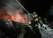 Los bomberos extinguen un incendio y limpian los escombros de un edificio residencial de cinco pisos que fue alcanzado por un misil balístico en Járkov, el 7 de marzo de 2026.