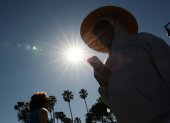 Una persona lleva un sombrero para protegerse del sol matutino mientras camina por The Strand en Redondo Beach, California, el 20 de marzo de 2026, durante una ola de calor.
