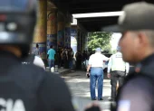 Policías y agentes de tránsito inspeccionan la escena del ataque armado en la vía a la costa, en Guayaquil, donde dos uniformados fueron asesinados tras una persecución desde Santa Elena.