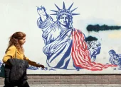 Una mujer camina junto a un mural antiestadounidense cerca de la antigua Embajada de EE. UU. en Teherán.