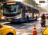 Un bus de transporte público circula por una intersección urbana mientras agentes realizan controles de tránsito para prevenir infracciones y siniestros viales.