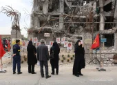 Varias personas se reúnen para observar fotografías de los fallecidos en un ataque aéreo estadounidense-israelí contra un edificio residencial, expuestas frente al mismo edificio que fue alcanzado en Teherán, Irán, el 13 de abril de 2026.