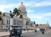 Un triciclo y varias motocicletas eléctricas circulan frente al Capitolio este martes 14 de abril de 2026,en La Habana (Cuba).