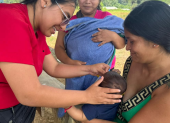 Médica aplica dosis de vacunas a un bebé, en una población de Ecuador.
