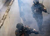 Soldados avanzan entre humo y concreto durante las maniobras conjuntas realizadas en Guayaquil.