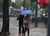 Personas se movilizan bajo la lluvia que sorprendió a la ciudad en horas de la tarde.