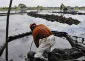 Fotografía de referencia de un empleado de la estatal Petróleos Mexicanos (Pemex) en medio de una extracción de crudo vertido durante un derrame de combustible.