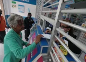 Una mujer de la tercera edad muestra una receta médica para comprar fármacos.