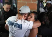 Personas se abrazan durante un velorio por las víctimas mortales de la explosión de un cilindro bomba en Cajibío (Colombia).