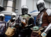 Visitantes caracterizados como personajes de The Mandalorian y Grogu posan frente a la atracción “Star Tours: The Adventures Continue” en Tokyo Disneyland, en Urayasu.