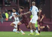 José María Canale (c) de Lanús disputa un balón con Jeison Medina (i) de Liga de Quito en el partido que los albos terminaron perdiendo 1-0  por la fase de grupos de la Copa Libertadores, en Argentina.