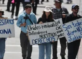 Personas sostienen carteles durante la masiva marcha por el Día Internacional del Trabajo, este viernes 1 de mayo de 2026, en Quito.