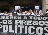 Personas sostienen carteles como parte de una manifestación para denunciar la situación de los presos políticos en cárceles de Venezuela este lunes, en Caracas (Venezuela).