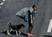 Un hombre camina junto a un perro por una calle del bulevar Fuerzas Armadas este jueves, en Tegucigalpa (Honduras).