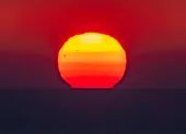 El sol se pone sobre la línea del horizonte en el mar, en una imagen de archivo.