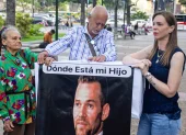 Familiares de Víctor Hugo Quero Navas, quien fue detenido hace más de un año en Venezuela, sostienen un cartel.
