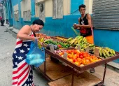 Una mujer vestida con los colores de la bandera de Estados Unidos compra frutas a un vendedor ambulante este viernes, en una calle de La Habana (Cuba).