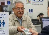 Referencial. Un adulto mayor recibe su pensión en una ventanilla del IESS.