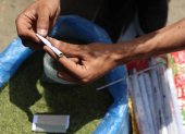 Un vendedor enrolla hojas de molokhia, también conocidas como malva de yute, que normalmente se usan en la cocina, para hacer un cigarrillo el 19 de abril de 2026.