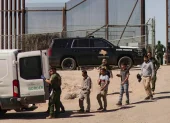Migrantes detenidos son llevados por miembros de la Patrulla Fronteriza estadounidense a un vehículo, junto al muro fronterizo en El Paso, Texas (EE.UU).