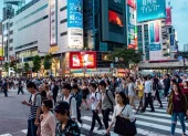 Fotografía de personas transitando un paisaje urbano en Japón.