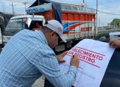 Una autoridad firma un sello que pusieron a una piladora que fue clausurada.