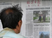 Un hombre lee un periódico en Pekín sobre la visita de Donald Trump a Xi Jinping.
