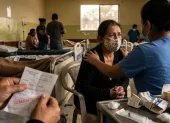Una paciente recibe consuelo en un sistema de salud que lucha contra el desabastecimiento.