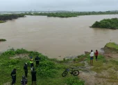 Fotografía de archivo que muestra a personas observando las inundaciones en la localidad de Chanduy en Santa Elena.