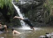 Jóvenes se bañan en una pequeña cascada en el cerro Azul de Guayaquil.