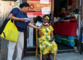 Una promotor (izquierda) entrega kits de herramientas comerciales para la Copa Mundial 2026 a una propietaria de un pequeño negocio en el barrio de Little Haiti, en Nueva York.