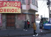 Unas personas pasan al pie de un negocio cerrado por el paro que hay en Bolivia.