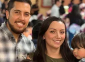 Mathias, de 3 años, junto a sus padres en una reunión con ambiente festivo.