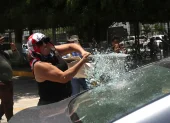 Una persona vandaliza un vehículo este martes, durante una protesta de integrantes de la Coordinadora Nacional de Trabajadores de la Educación (CNTE), en Chilpancingo (México).