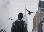 Escena urbana en Nueva York, con el Empire State entre la neblina y aves en vuelo.
