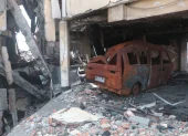 Entre los escombros del centro comercial Multicomercio hay carrocerías de vehículos.