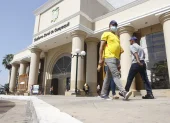 Personas caminan al pie del edificio del Gobierno Zonal de Guayaquil.