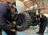 Un par de trabajadores cumplen su jornada en una fábrica de carros.