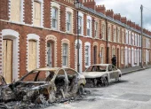 Se puede ver un coche calcinado en la calle McMaster tras los disturbios ocurridos en Belfast, Irlanda del Norte, el 10 de junio de 2026.