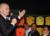 El presidente de la FIFA, Gianni Infantino, se dirige al público durante un evento oficial rodeado de camisetas históricas de selecciones nacionales.