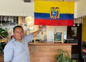 Segundo López posa con orgullo junto a la bandera tricolor que adorna su restaurante, "El Sazón de Doña Eva", en Upper Darby.
