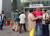 Adultos mayores en el exterior del edificio del Servicio de Rentas Internas, en Guayaquil.