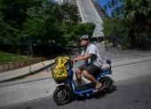 El repartidor de comida a domicilio Joao Paulo Teixeira, de 20 años, entrega un pedido para la aplicación 99Food en su bicicleta eléctrica en el centro de Río de Janeiro, Brasil, el 17 de abril de 2026.