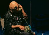 La obra transcurre en un espacio íntimo que remite a una sala. Desde allí, el intérprete comparte pensamientos, canciones y acciones performáticas