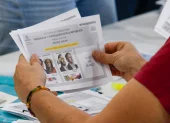 Ciudadano sostiene la papeleta de la segunda vuelta presidencial en Colombia, mientras el CNE reinicia el escrutinio sin definir aún al ganador.