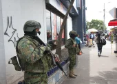 Dos militares resguardan una zona de afluencia de civiles en una ciudad.