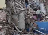 Residentes caminan entre los escombros de edificios derrumbados tras los terremotos en Catia La Mar, estado La Guaira.