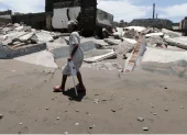 Una habitante de la aldea camina frente a escombros de casas destruidas en Cedeño, al sur de Honduras. El poblado lleva 30 años sufriendo el avance del mar.