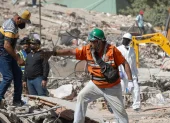 Rescatistas y voluntarios trabajan entre los escombros tras los sismos en La Guaira, Venezuela.