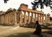 Un hombre se sienta a la sombra frente al Templo de Zeus en el sitio arqueológico de Cirene,en la costa mediterránea nororiental de Libia, el 18 de mayo de 2026.